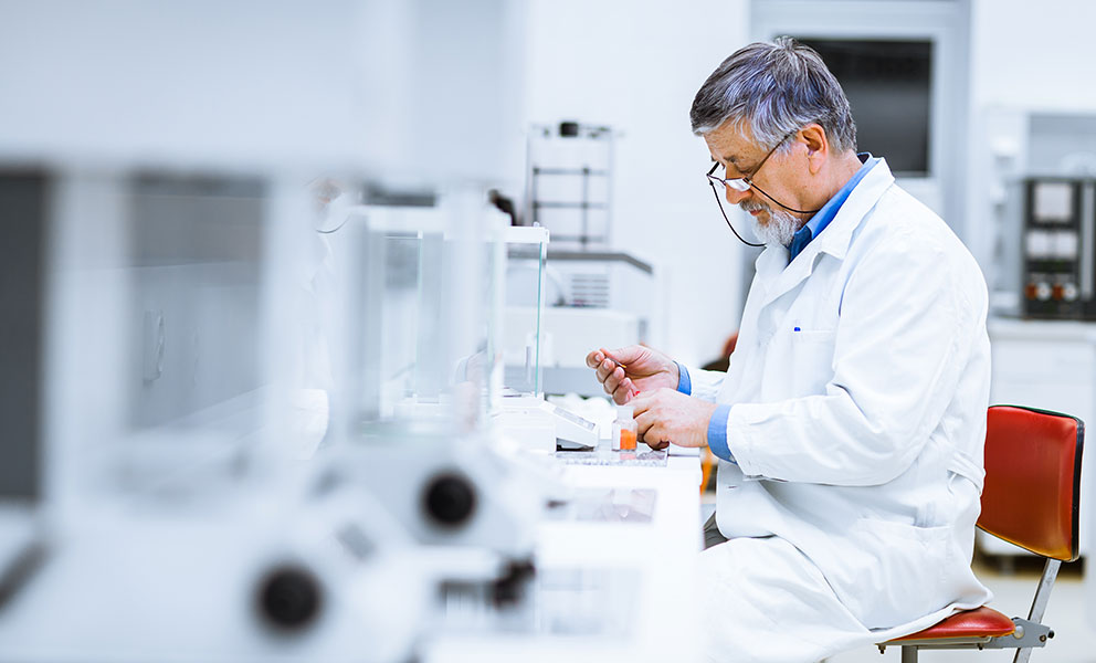 Senior male researcher carrying out scientific research in a lab (shallow DOF; color toned image)